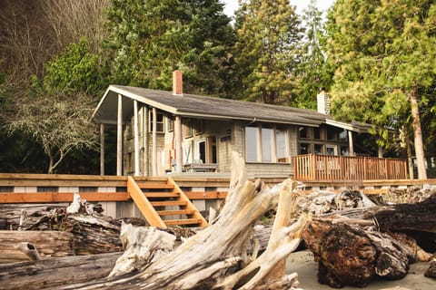 View of house from beach with seawall and stairs 