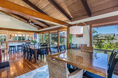 Share meals at the large dining table, surrounded by natural light and tropical garden views.