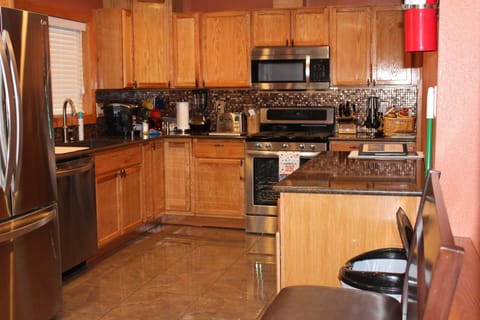 Kitchen with quartz counters, all stainless steel appliances  movable island.
