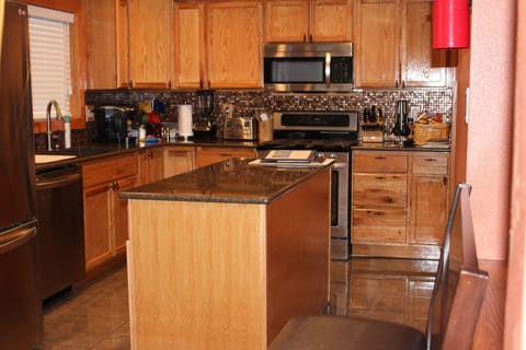 Remodeled kitchen showing movable island in center of kitchen.
