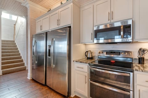 Stairs to upper level; 2 refrigerators; standalone ice-maker not seen.