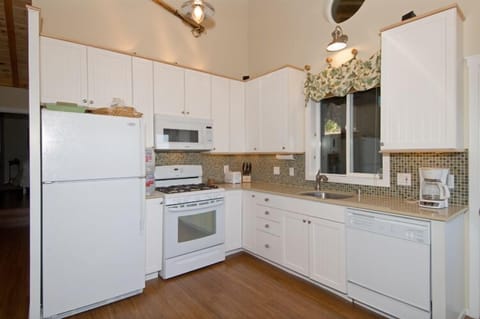 Fully stocked kitchen with gas range. Window looks out to the pine grove.