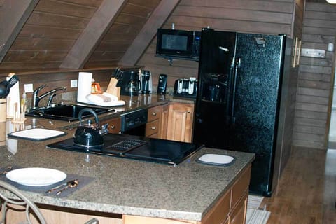 Full kitchen with large granite counter and bar
