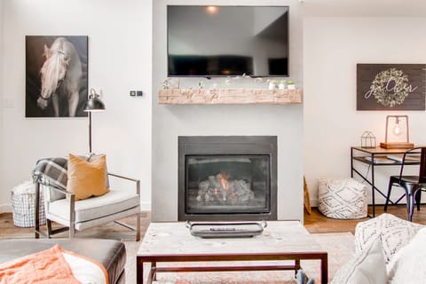 Cozy fireplace with reclaimed beam, smart tv, sectional leather couch