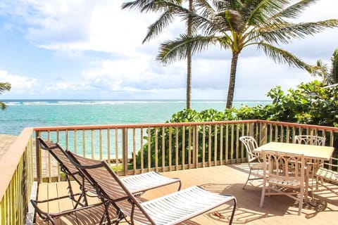 Enjoy the expansive deck overlooking the ocean framed by two tall coconut trees