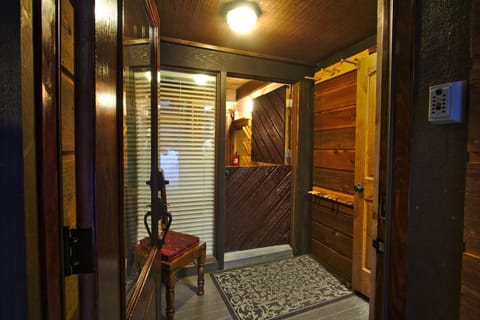 Off the carport is the glass entry door to the enclosed mudroom with ski storage