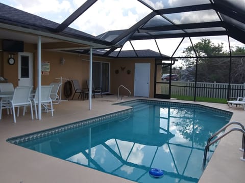 Large pool with dining area and pool storage room.