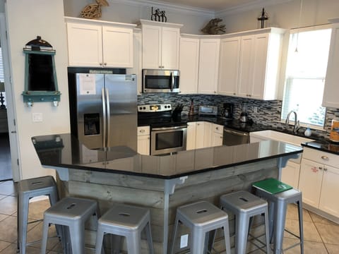 Fully stocked kitchen, breakfast counter seats additional 6