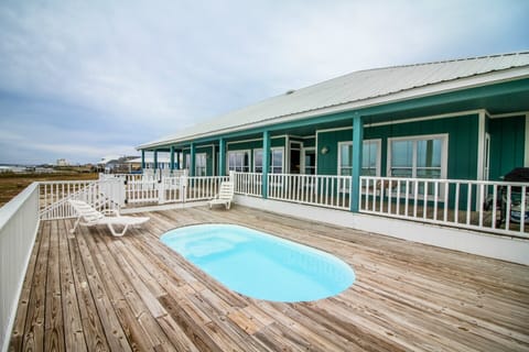 Pool deck and back deck leads down to waterfront with pier
