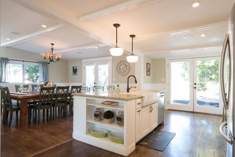 Large island with farmhouse double sink, bar seating and dining room