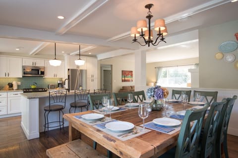Open plan kitchen with large island and 3 bar seats adjacent to dining area