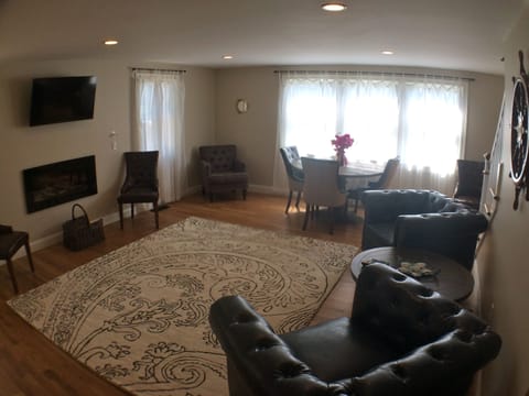 Living / Dining area, table with seating for 6, two leather chairs, flat tv
