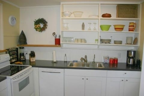 Kitchen with plenty of dishes, dishwasher, coffee, tea, and spices