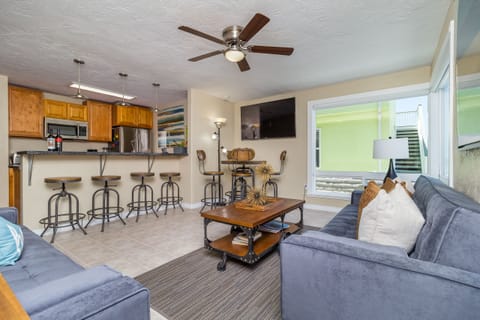 Living and dining area with large ocean view windows, open to kitchen