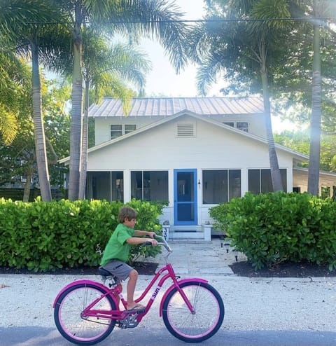 A favorite repeat renter riding his bike in front of my historic 1911 cottage.