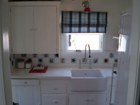 Nautical kitchen with porcelain deep sink and 'tattoos' tiles. 