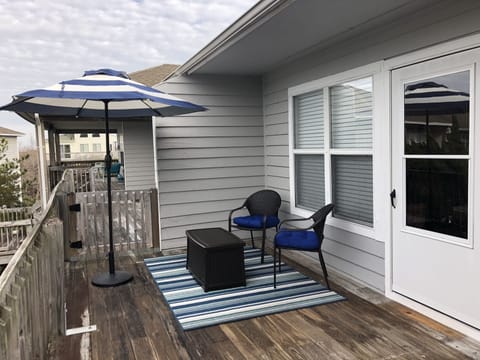 A front deck overlooks the pool area and has room for seating and dining.
