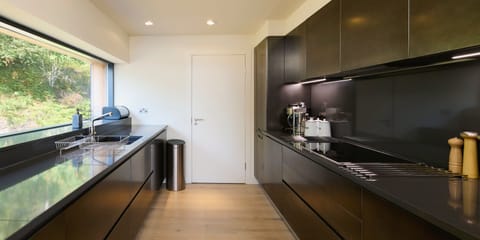 The clean lines of the smart kitchen and the wall-length picture window