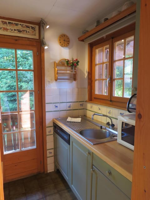 The kitchen from the hallway, with a window to the front & doors to the balcony.
