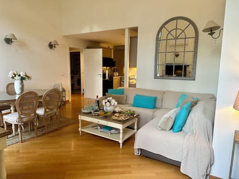 Air-conditioned furnished living/dining room with kitchen in the background