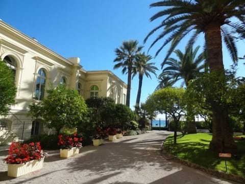 View of apartment's tall windows from the shared gardens of Le Regina residence