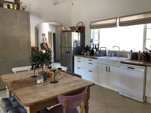 Open plan kitchen and dining area open on to outdoor dining terrace on the left