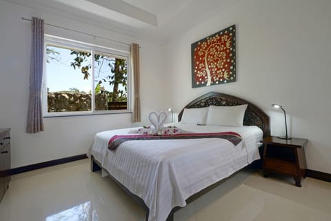 Bedroom 3 with a king-size bed, air-conditioning and en-suite bathroom.