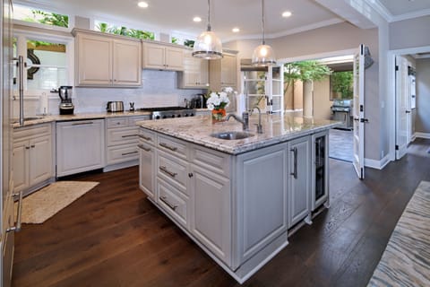 The large kitchen, adjacent to private outdoor patio with dining table and grill