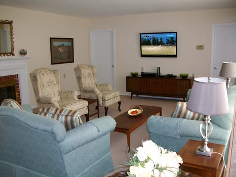 Living Room view with entrance to Kitchen and Dining Room. Large screen HDTV