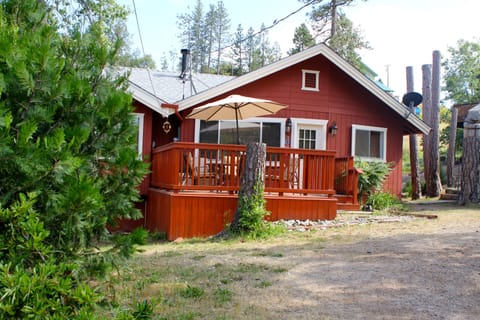 Front of cabin with deck and patio furniture.