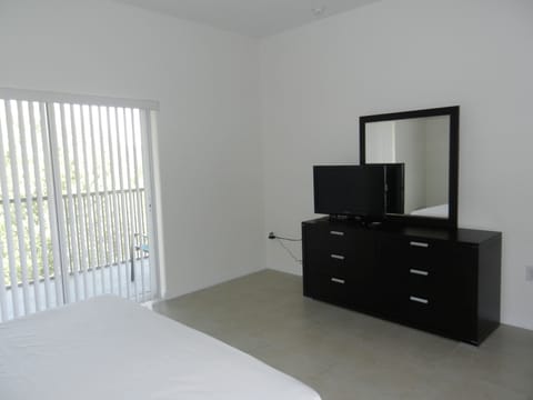 Master Bedroom with flat panel HDTV, mirror, and access to the outdoor patio.