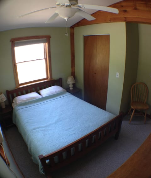 The bedroom has a ceiling, fan, ample closet space and a dresser and