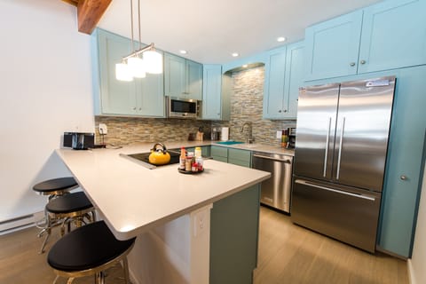 Newly remodeled kitchen with stainless steel appliances and quartz countertops.
