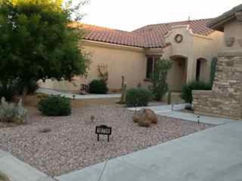 The front of the house has a welcoming desert landscape.