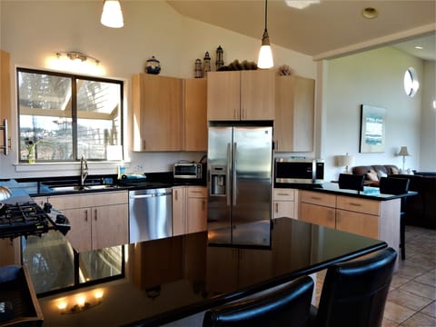 Kitchen has large supply of dinnerware, utensils, pots and pans, and bar glasses