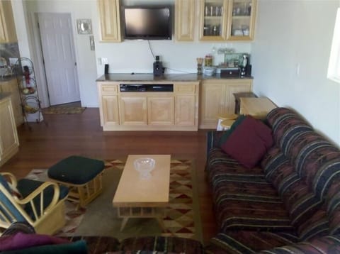 Living room: L shaped couch, gliding chair, bar area, T.V,