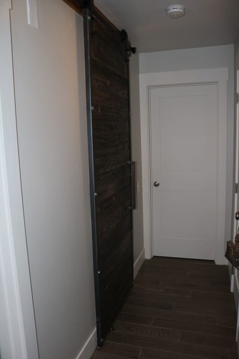 Hall with barn door to bathroom, master bedroom door straight ahead 