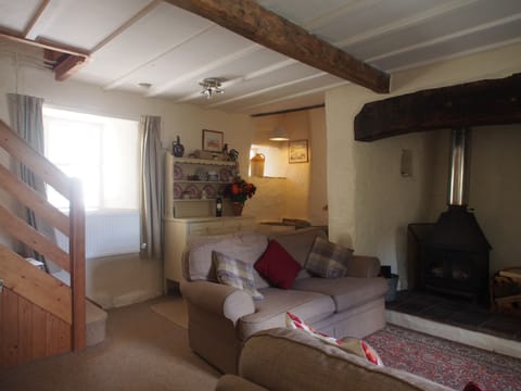 Cosy beamed sitting room with wood burning stove