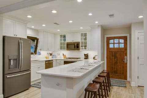 The kitchen--quartz countertops, the 4-seat breakfast bar & GE Profile fridg