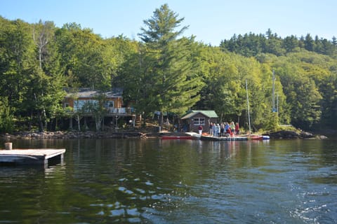 The view of the cottage and boathouse from the lake, and  the family on the dock