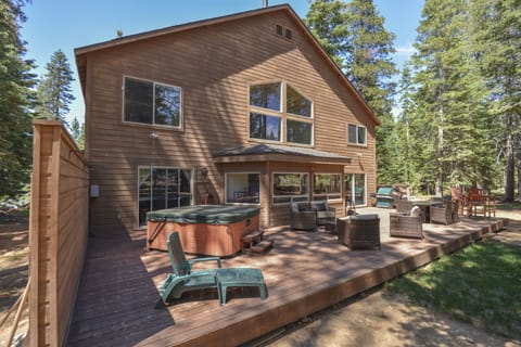 Back of the home-equipped with a hot tub, grill and outdoor furnishings