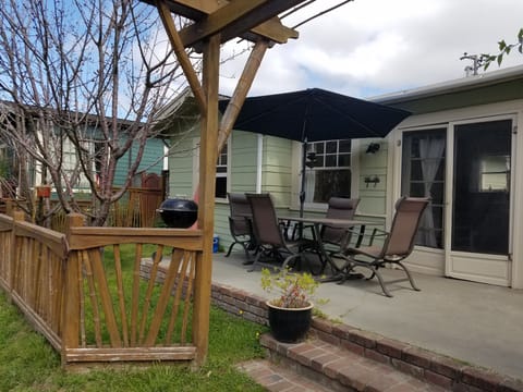 Porch seating with shade umbrella and cherry trees