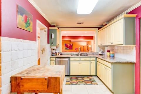 Colorful fully equipped kitchen with numerous cookware.