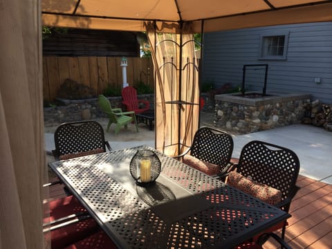 Outdoor dining table under canopy-rotisserie grill and propane bbque
