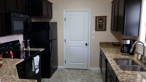 Fully equipped kitchen with coffee maker and basic spices. Door leads to garage.