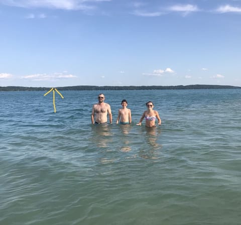 My nephew and kids on sandbar across lake. Arrow points at our cottage.