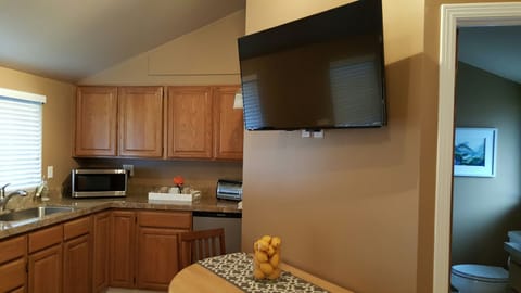 Dining with flat-screen TV & view to kitchenette