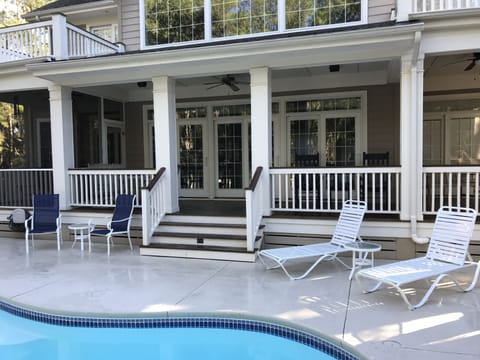 Large rear deck with a screened in porch area overlooking the private pool.