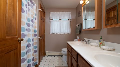 Hall Bath with double sinks, full bathtub/shower, and linen closet