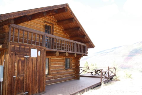 Back of cabin, with balcony off of the upstairs loft that has three queen beds